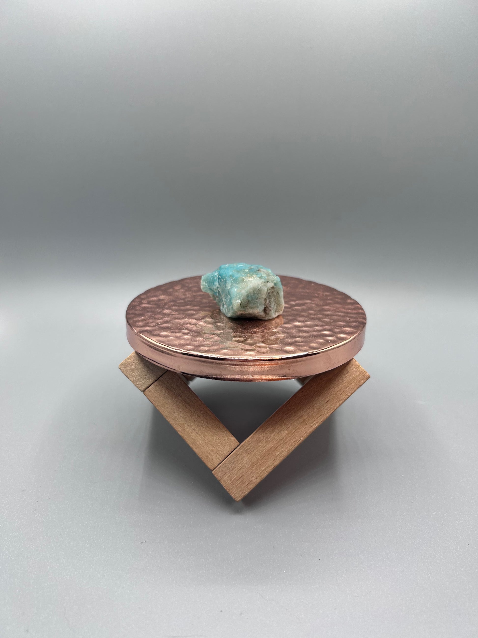 amazonite stone posed inside on copper plate.