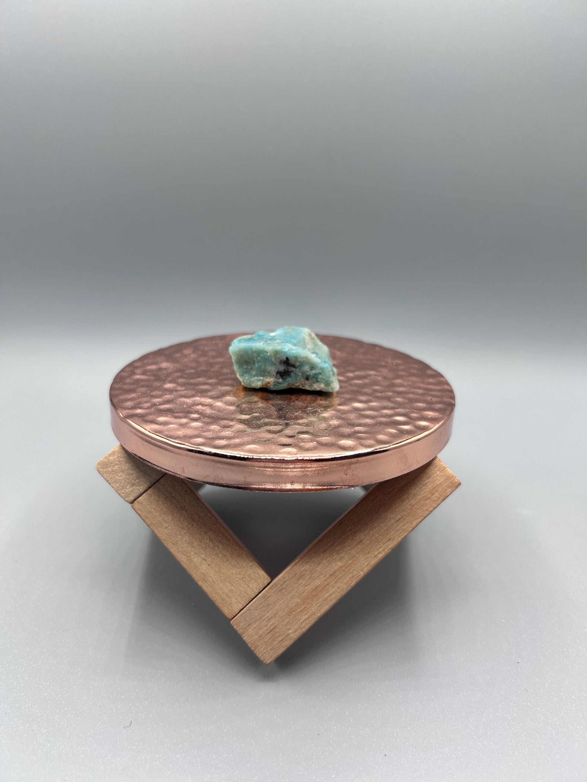 amazonite stone posed inside on copper plate.